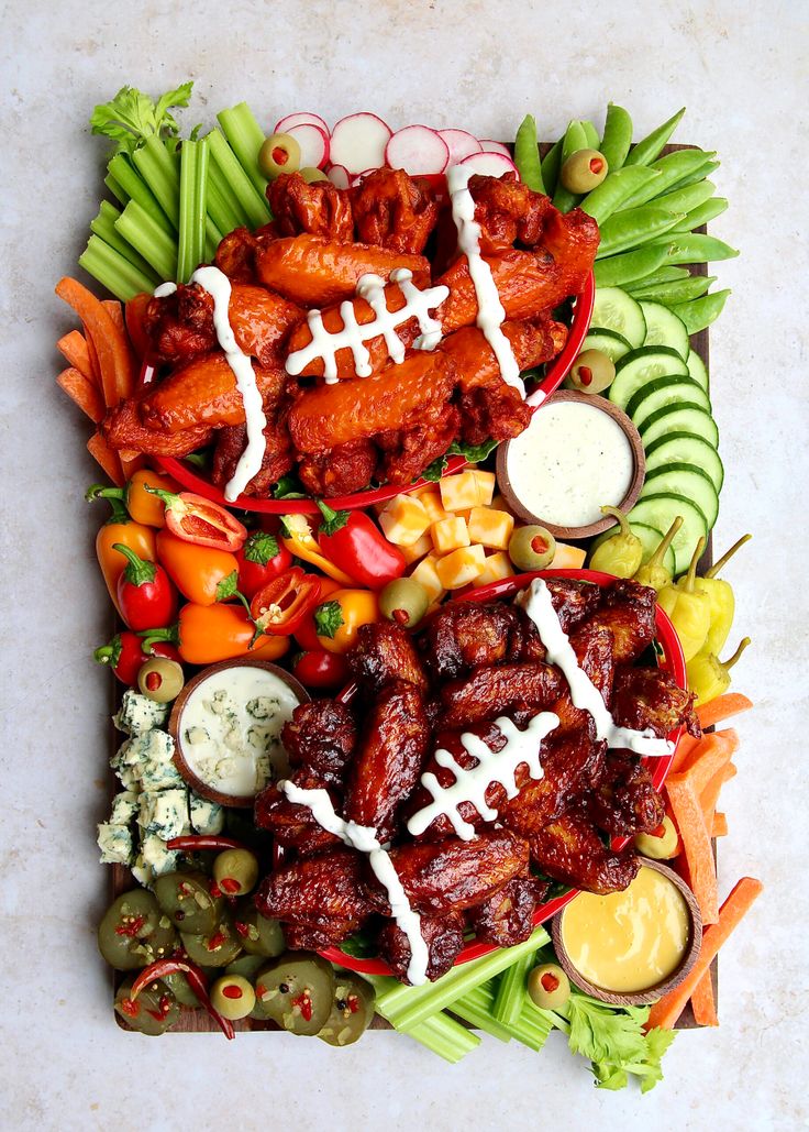 a football platter with meats, veggies and dip