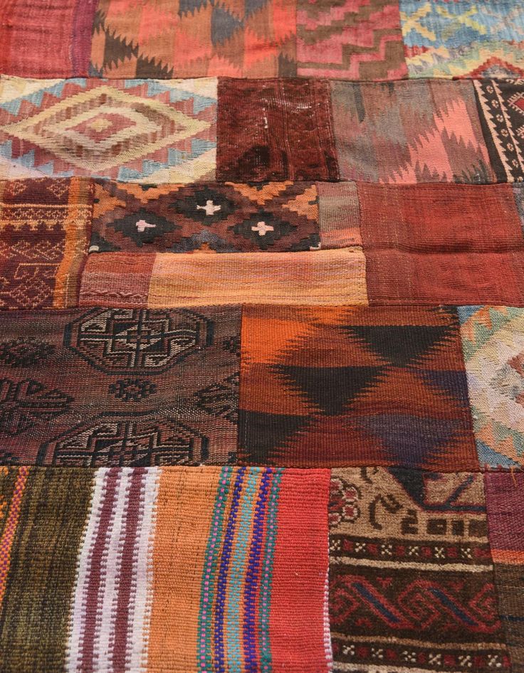 an old patchwork rug with many different colors and patterns on it's surface