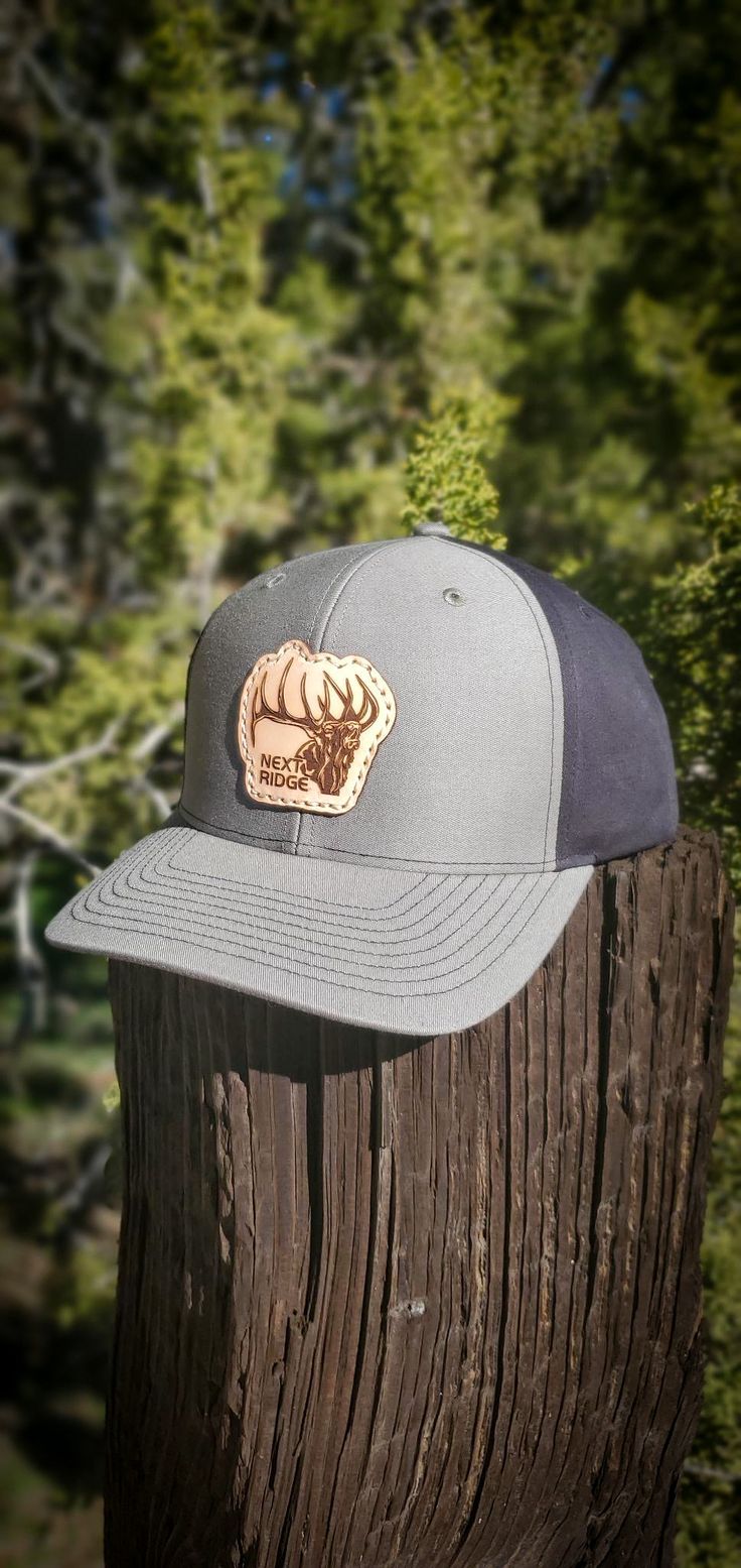 Introducing the Screamin Bull Elk Leather Patch Hat from Next Ridge Apparel, the perfect accessory for the outdoors enthusiast in your life. This premium hat is crafted from durable, high-quality materials and features a stylish leather patch featuring a screaming bull elk design. The hat is designed for casual, everyday wear, making it a versatile addition to your wardrobe. Whether you're out hunting, fishing, hiking, or camping, this hat will keep you comfortable and protected from the element Leather Patch Hat, Bull Elk, Patch Hat, Hunting Fishing, Leather Patches, Casual Everyday, The Outdoors, Elk, Hunting