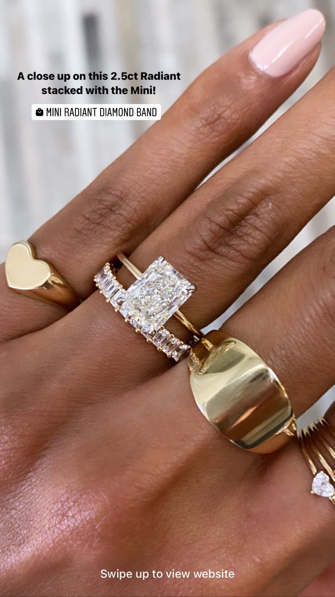 a woman's hand with three different rings on her fingers and one has a heart shaped