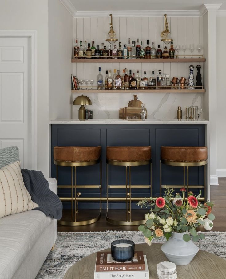 a living room filled with furniture and lots of bottles on top of the shelves next to a bar