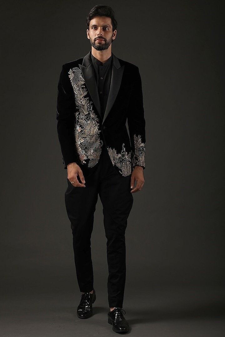 Elevate your style with our Men's Made-to-Measure Black Velvet Blazer, adorned with intricate heavy floral hand embroidery. This exquisite piece is the perfect choice for groomsmen, weddings, or sophisticated cocktail events. Impeccably tailored to your measurements, it exudes luxury and refinement, making a statement that seamlessly blends tradition with contemporary elegance. Step into the spotlight with this unique and distinguished outfit, showcasing your individuality in every stitch.  Welcome to THE MAGNUS ATELIER on Etsy! We want to ensure your shopping experience is delightful and transparent. Please take a moment to review our shop policies before purchasing: 1. Processing Time: Each item is carefully crafted and made to order. Please check the individual product listing for the e Traditional Black Tuxedo For Groom, Traditional Black Groom Tuxedo, Designer Wedding Sets With Floral Embroidery, Fitted Black Sherwani For Ceremony, Embroidered Fitted Sherwani For Groom, Designer Black Unstitched Suit For Wedding, Fitted Unstitched Suit With Resham Embroidery For Groom, Formal Velvet Sets With Zari Work, Black Wedding Sets With Gold Embroidery