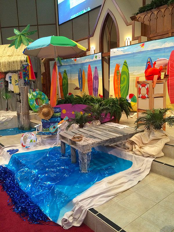 an indoor display with surfboards and decorations on the walls, including a fountain in the center