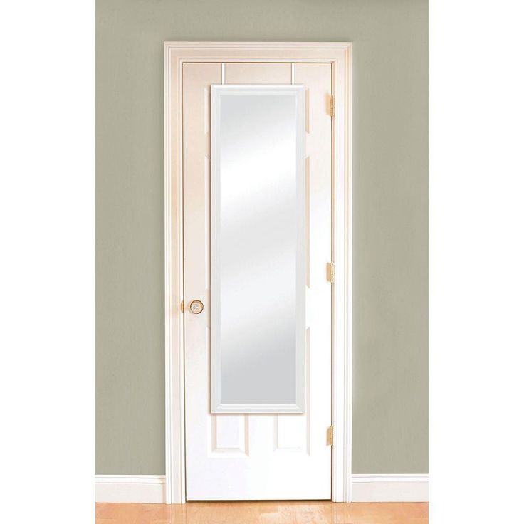 an empty room with a white door and mirror