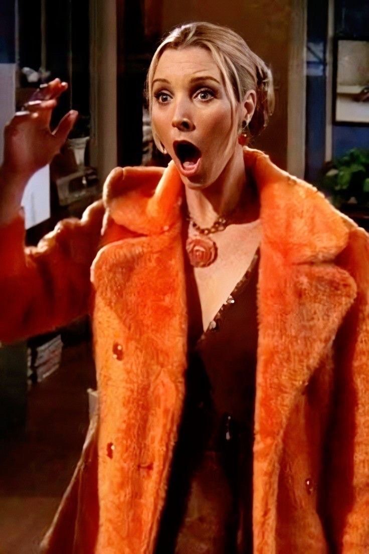 a woman in an orange coat making a surprised face