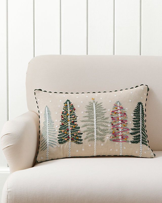 a white chair with a christmas tree pillow on it