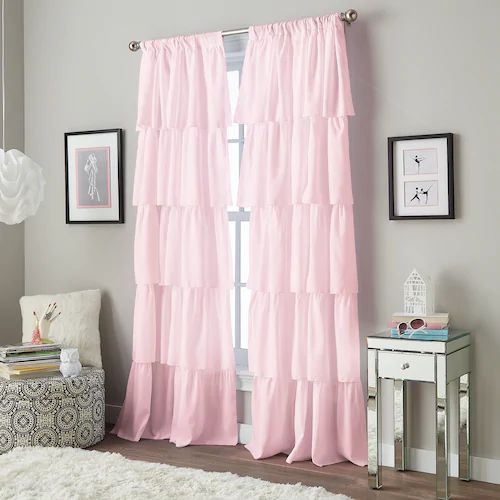 a bedroom with pink curtains and a white rug on the floor in front of a window