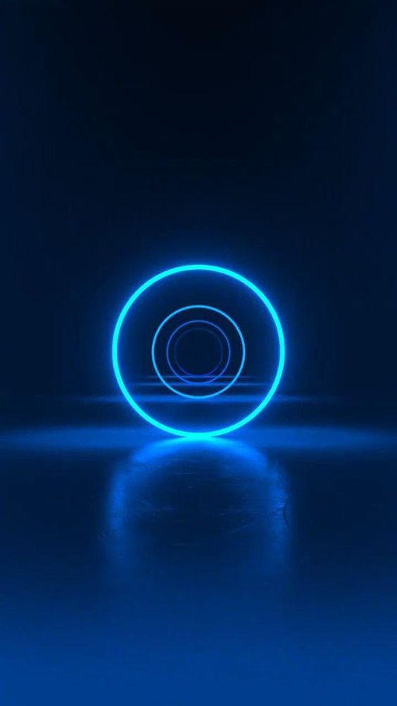 a neon blue circle on a dark background with reflections in the floor and light coming from it