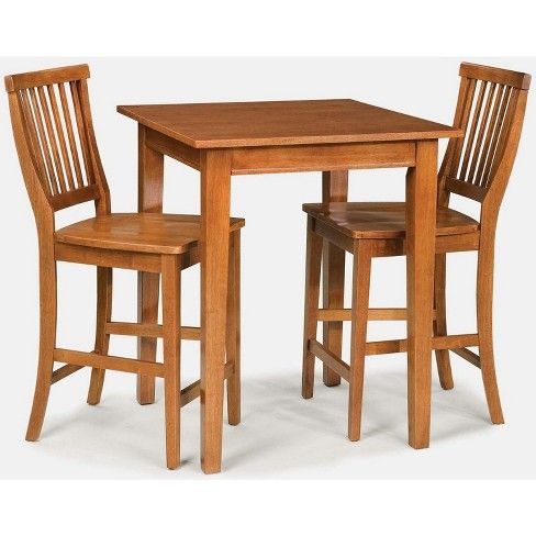 a small wooden table and two chairs with one chair up to the other, set against a white background