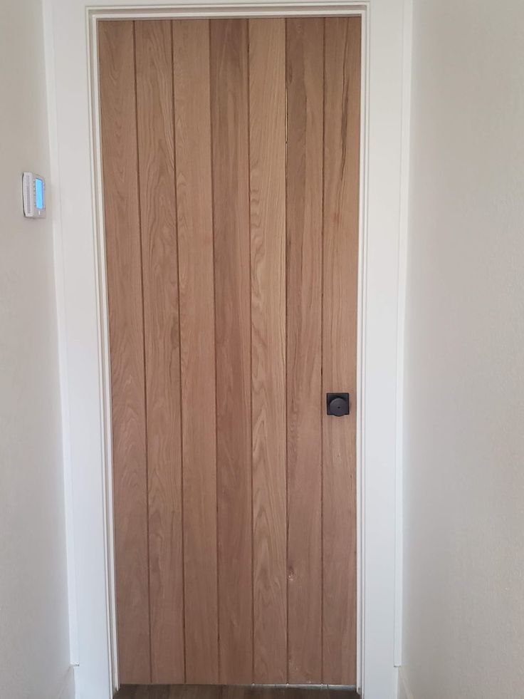 the door is made of wood and has a black handle on it's side