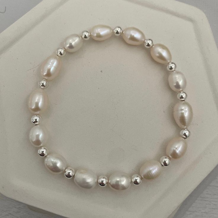 A gorgeous pearl stacker, this piece will look stunning in any bracelet stack. Sure to become your new favorite everyday staple. 4mm quality sterling silver beads strung on super strong stretch cord accented 8mm baroque pearls. A classic piece that you'll love and want to wear time and again. How to figure out your wrist size: use a soft measuring tap to measure your wrist. make sure to wrap the measuring tape around your wrist so that it makes contact with your skin all the way around, measure Pearl Bead Bracelet, Beads Bracelet Design, Bead Stringing, Measuring Tape, Initial Charm, Personalized Necklace, Baroque Pearls, Bracelet Stack, Sterling Silver Bead