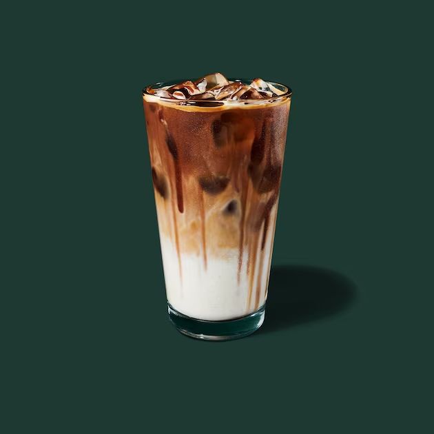 a tall glass filled with ice cream and chocolate syrup on top of a green background