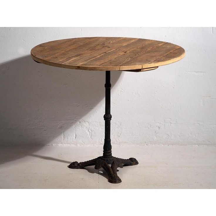 a round wooden table sitting on top of a white floor