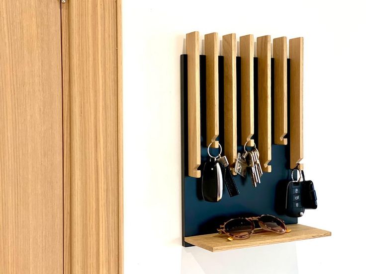 a wall mounted rack with keys and sunglasses on it