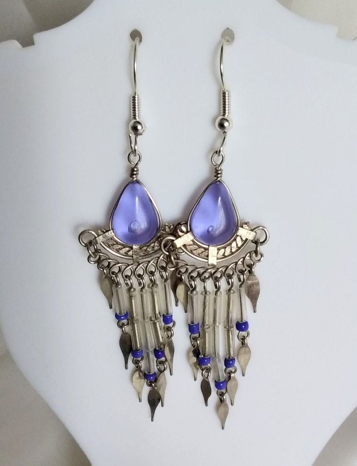 Delightful transparent purple glass earrings finished off with transparent and blue beads and white metal decorations. The teardrop shaped glass pieces measure 8x12mm.  Fitted with non-allergenic earring hooks. Purple Teardrop Metal Jewelry, Purple Nickel-free Teardrop Dangle Earrings, Nickel Free Purple Teardrop Crystal Earrings, Nickel-free Purple Teardrop Crystal Earrings, Purple Teardrop Metal Earrings, Purple Teardrop Beaded Earrings With Ear Wire, Purple Beaded Teardrop Earrings With Ear Wire, Purple Teardrop Beaded Earrings, Nickel Free Teardrop Purple Earrings