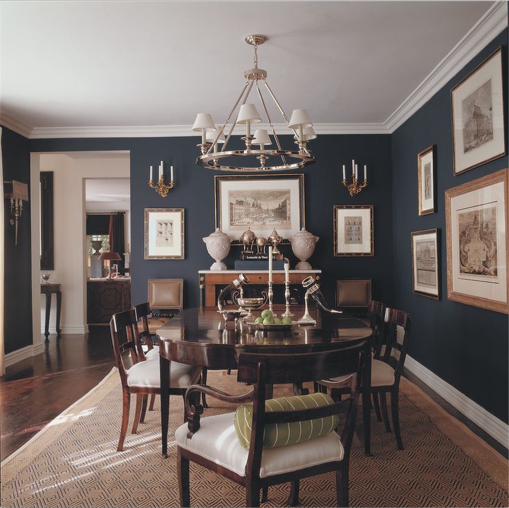 a dinning room with blue walls and pictures on the wall, including a chandelier