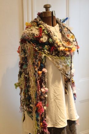 a woman wearing a white shirt and multicolored scarf on top of a mannequin