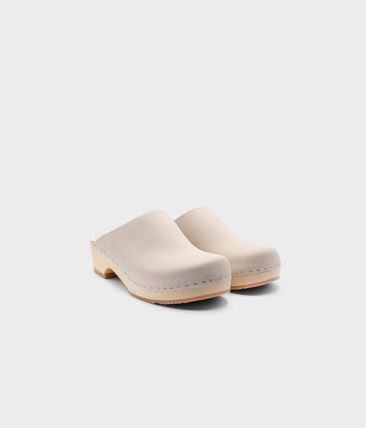 Elevate your everyday style with our minimalist clog mule, featuring clean lines and a timeless aesthetic that effortlessly transitions from day to night. Clog measurements:Heel height: 1 3/4” (4.5 cm)Toe height: 1 5/8″ (4.1 cm) Fit:RegularLeather:Nubuck leather Clogs consist of:Base: European Lime Wood Sole: Rubber sole Fastening: Staples Classic Everyday Slip-on Clogs, Classic Leather Clogs For Everyday, Everyday Leather Sole Clogs, Classic Clogs With Leather Sole For Everyday, Everyday Closed Toe Clogs With Rubber Sole, Classic Mules With Wooden Heel, Solid Color Slip-on Clogs With Rubber Sole, Classic Clogs With Removable Insole, Classic Open Heel Mules With Rubber Sole