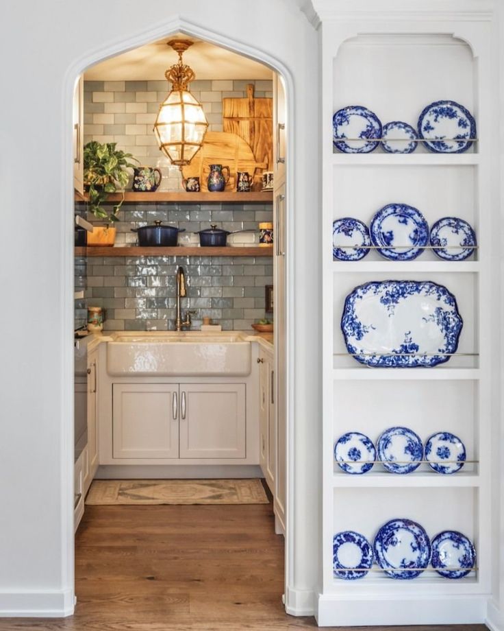 an open door leading to a kitchen with blue and white plates on the shelves in front of it