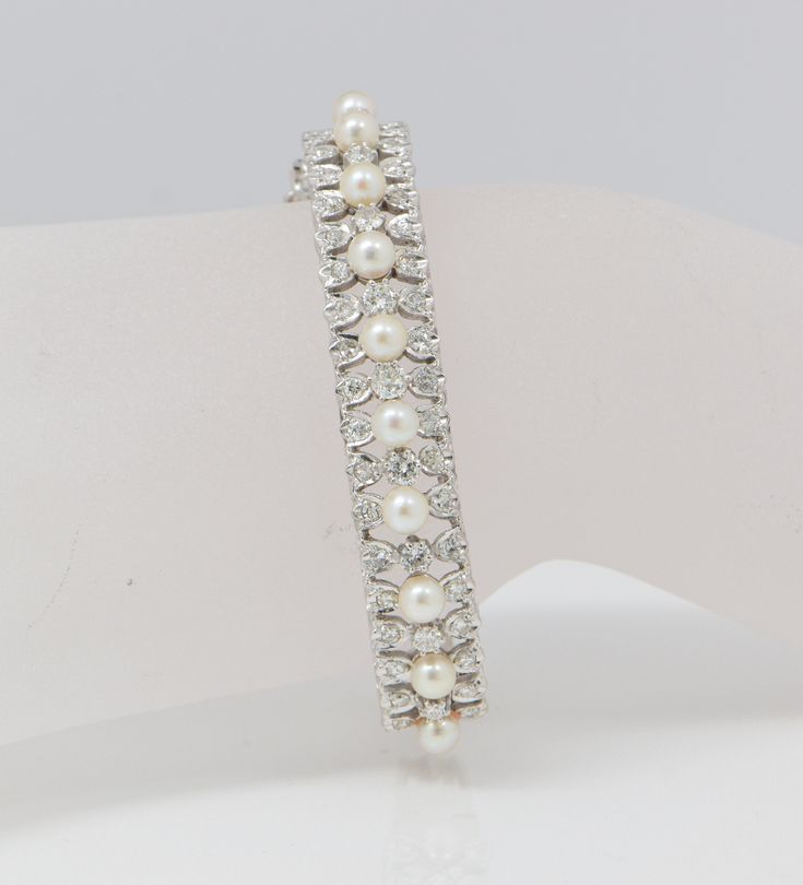 "This is a 14K WG Edwardian style diamond and pearl hinged bangle bracelet with 10 - 5 mm pearls surrounded by 47 round faceted diamonds 2 1/4\" interior 1/2\" width on top, guard chain diamonds graduate from center, approximately 2 ct diaonds, color H, clarity SI1, 34.3 grams Stock # BB62B24" Pearl Diamond Bangle, Classic Diamond Bracelet With Oyster Style For Wedding, Classic Diamond Oyster Bracelet For Wedding, Classic Diamond Pearl Bracelet For Formal Occasions, Pearl Wedding Bracelet With 17 Jewels, Elegant Pearl Bracelet With Diamond Accents, Fine Jewelry Pearl Bracelets For Wedding, Luxury Pearl Bracelets For Wedding, Fine Jewelry Diamond Pearl Bracelet For Anniversary