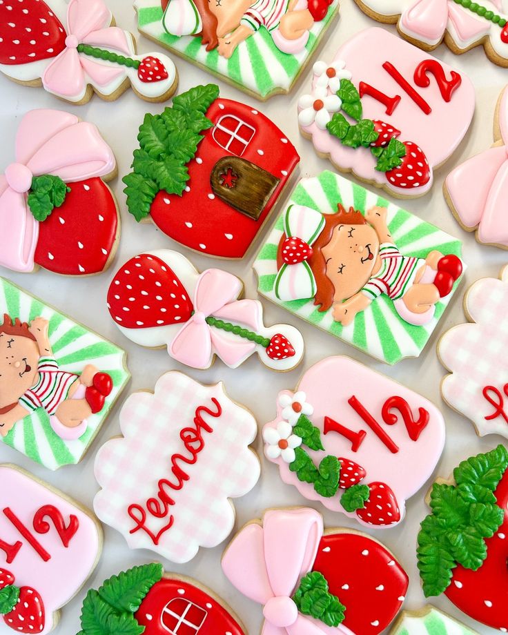 decorated cookies with numbers and images on them are arranged in the shape of strawberrys