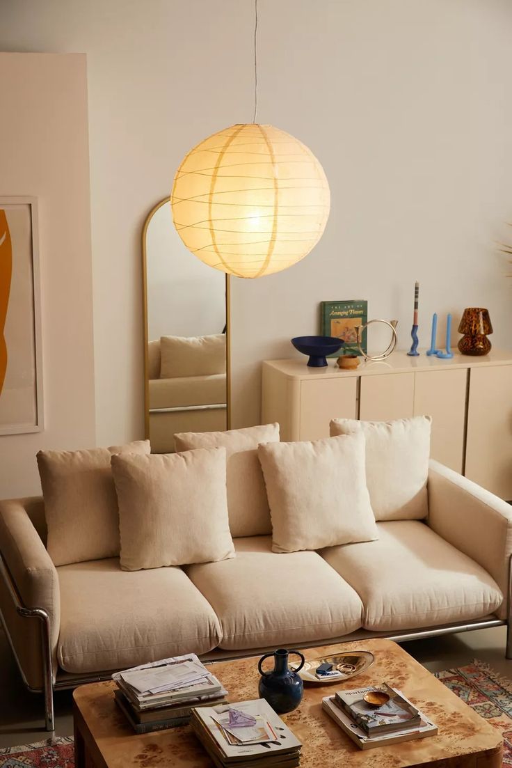 a living room filled with furniture and a large light fixture hanging over the top of it