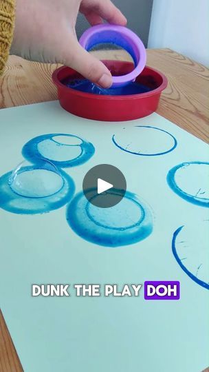 a child is painting with blue and purple paint on the paper that says dunk the play doh