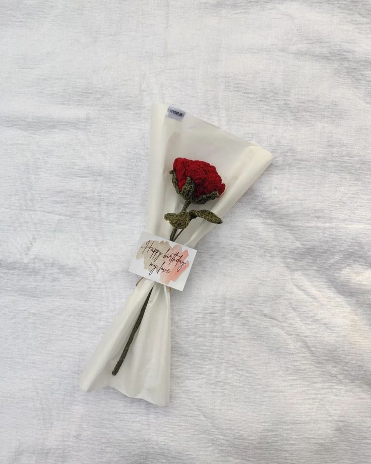 a white cloth with a red rose on it