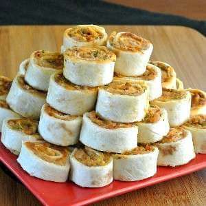 a red plate topped with rolls on top of a wooden table