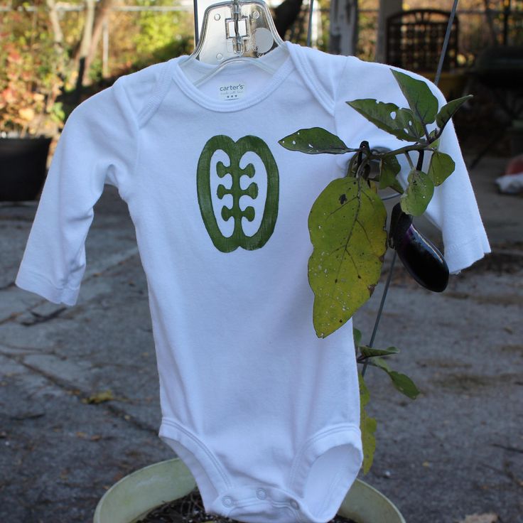 Baby t-shirt, long sleeved white with hand-printed green Adinkra design, Ese ne tekrema.  I print these shirts using stamps I have made myself. This design has been described as the teeth and the tongue, and can symbolize friendship and interdependence. There are currently three white, long sleeved baby shirts (bodysuits) in stock: one 12 month, one 18 month, and one 24 month. Please include a note with your order requesting the appropriate baby shirt size(s). 100% cotton The fabric paint on the Casual Green Long Sleeve Bodysuit, Green Long Sleeve Casual Bodysuit, Fitted Green Long Sleeve T-shirt, Green Long Sleeve Onesie For Spring, Green Fitted Casual Onesie, Casual Long Sleeve Graphic Bodysuit, White Cotton Long Sleeve Bodysuit, Long Sleeve Cotton Onesie With Graphic Print, Green Cotton Bodysuit For Spring