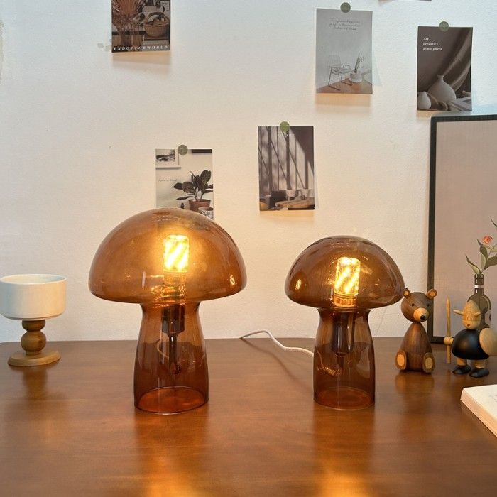 two brown glass lamps sitting on top of a wooden table