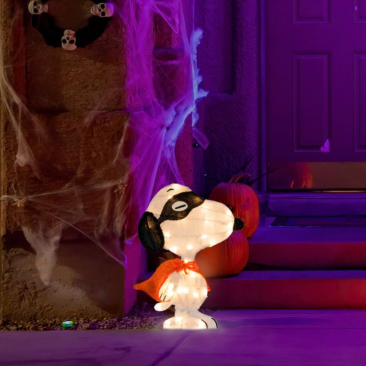 there is a light up snoopy on the ground next to some pumpkins and other decorations