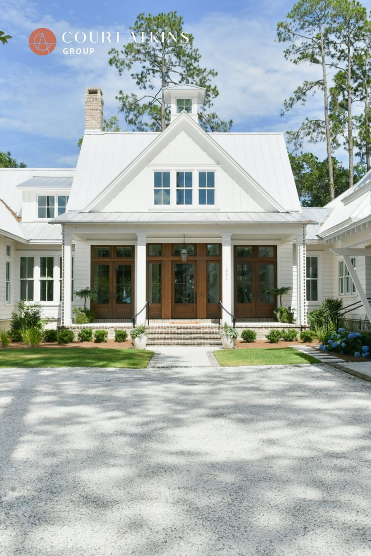 a large white house with lots of windows on it's front door and porch