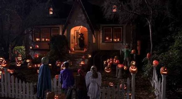 a group of people standing in front of a house decorated for halloween