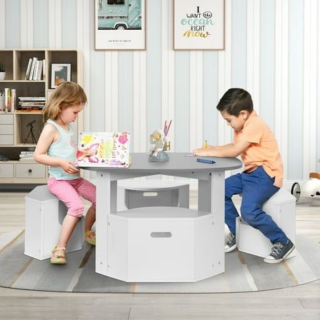 two children sitting at a table playing with toys