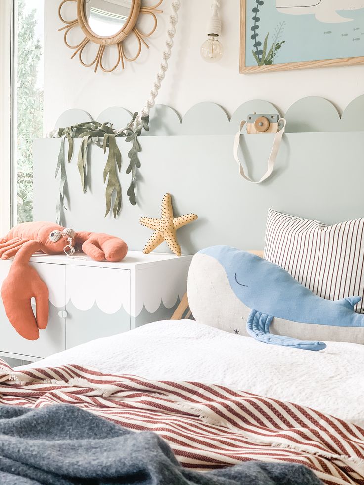 a child's bedroom decorated in blue, white and red with sea creatures on the wall