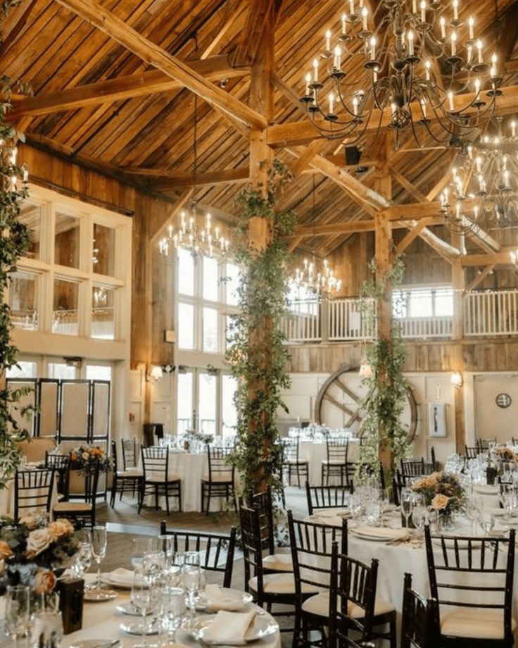 an indoor wedding venue with chandeliers and tables