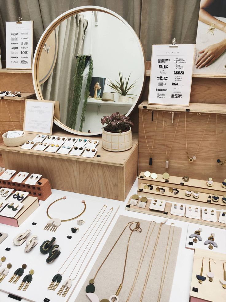 a table with jewelry on it and a round mirror in the middle surrounded by other items