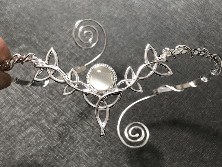 I've fabricated a truly Celtic upper arm cuff bracelet, or arm torc, in Celtic fashion with an 8mm round Moonstone shown for reference, but you can choose a myriad in the drop down menu. I designed this piece in sterling silver and an approximate size for the piece will fit most arm sizes, as you can squeeze it on for a secure fit. There's a total of 5 Trinity Knots that wonderfully matches this wedding circlet: https://www.etsy.com/listing/181351917/celtic-wedding-bridal-headpiece-circlet?ref=s Pretty Silver Bracelet, Silver Arm Jewelry, Silver Fantasy Jewelry, Arm Cuff Jewelry Silver, Adjustable Wire Wrapped Fantasy Jewelry, Fantasy Style Silver Jewelry With Unique Design, Fantasy Style Silver Bracelet, Adjustable Silver Fantasy Bracelet, Silver Fantasy Bracelet