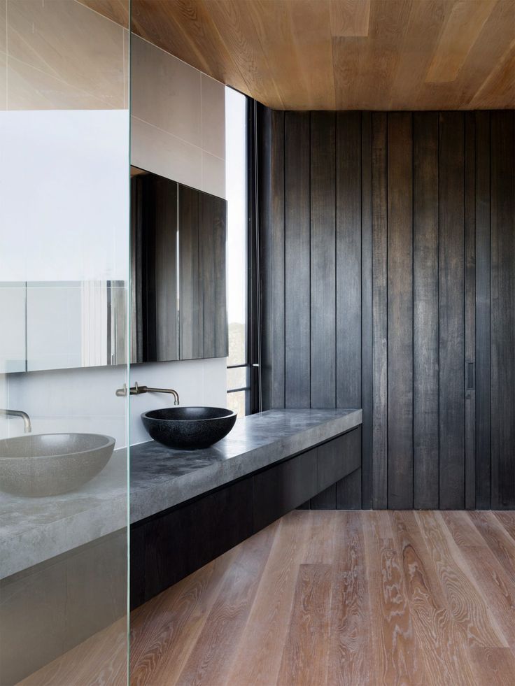 a modern bathroom with wooden walls and wood flooring, along with a vessel sink