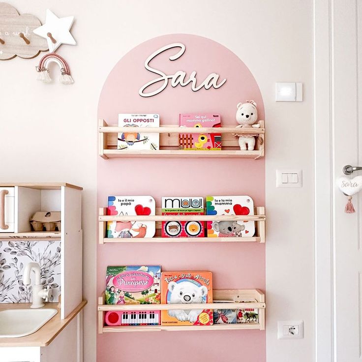 a child's room with pink walls and shelves