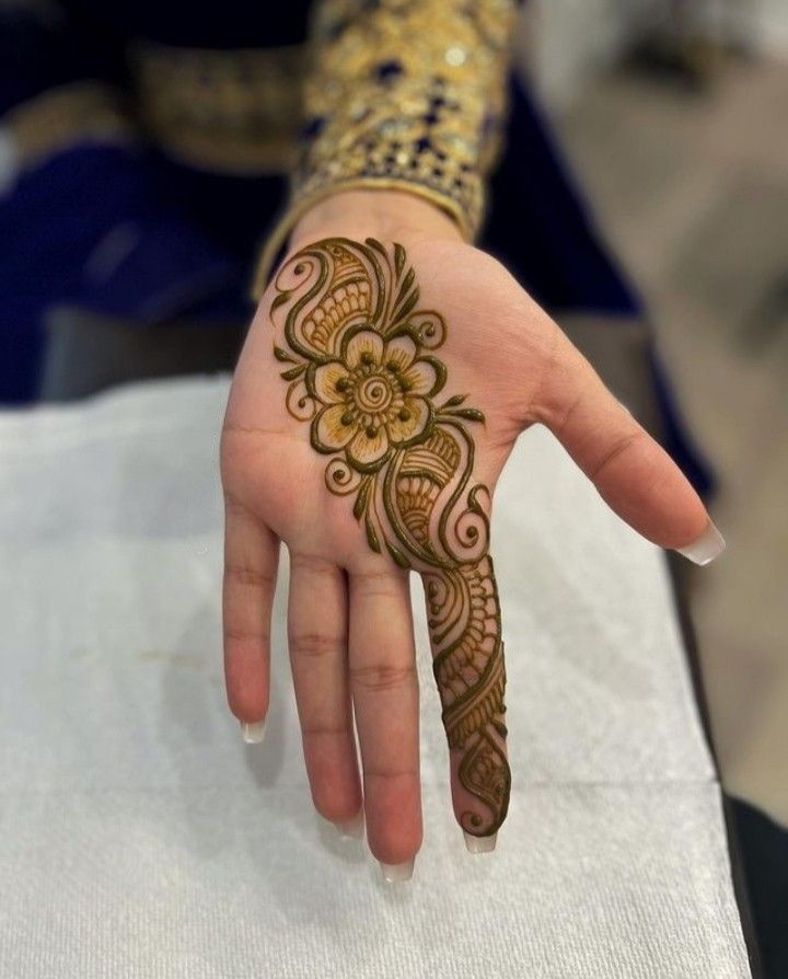 a woman's hand with henna tattoos on it