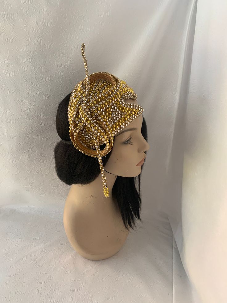 Absolutely beautiful! This is an elegant unique design gold OOAK (one of a kind) vintage 1960 styled pearl beaded with rhinestone jeweled half hat fascinator perfect for weddings, Mother of the Bride hat, Bridal fascinator hat, Church hats, COGIC women convention hats, tea parties and special occasion headpiece. Looking for a unique handmade fashion lover gift for women, then this is a perfect gift.  E A S Y  T O  W E A R  Forms to the contour of your head.  Light weight  Unique design Different ways to wear Ready to wear   elastic attachment to hold comfy  Gold  pearl with rhinestone trim covered on a lightweight millinery base and a satin underneath to protect hair. S H I P P I N G : Expedited shipping upgrades are available at check out. We use Our local postal service to reflect a more Handmade Gold Hat For Kentucky Derby, Gold Gatsby Headpiece For Party, Elegant Ceremonial Crown Headpieces, Gold Round Crown Costume Hat For Party, Gold Costume Hat With Round Crown For Party, Elegant Ceremonial Headpiece With Pinched Crown, Elegant Handmade Headpiece With Structured Crown, Glamorous Rhinestone Headpiece For Wedding, Gold Gatsby Style Formal Headpieces