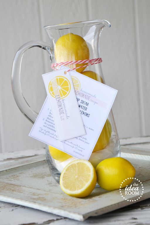 a glass pitcher filled with lemons on top of a table