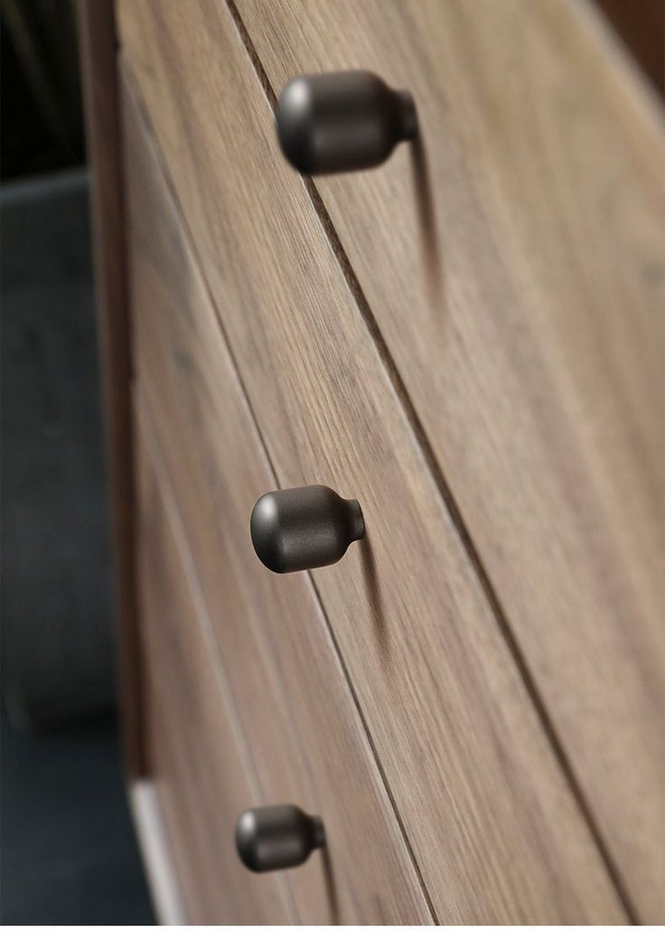 an image of a wooden dresser with metal handles