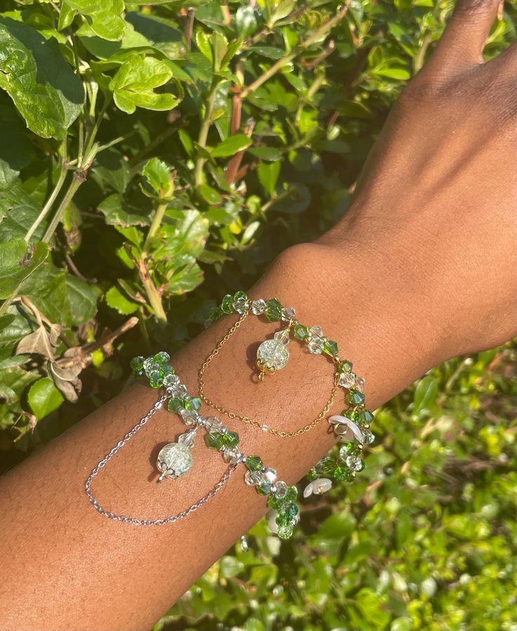 An earthy green charm adjustable bracelet 🌿🪷 Features ---------- --> Comes in Silver or Gold --> Cute white flower charms for decoration + handmade bead flowers attached --> ~18cm with extra 5cm extender chain Materials ---------- --> 4mm bicone beads --> Stainless steel gold and silver plated jump rings  --> Gold and silver steel wire  --> 2mm gold and silver seed beads  --> White pearl flower spacers Green Bracelet With Flower Charm As Gift, Green Resizable Beaded Bracelets, Green Beaded Bracelets With Flower Charm For Gift, Adjustable Green Bracelets With Flower Charm, Green Bangle Charm Bracelet For Jewelry Making, Elegant Green Bracelet With Flower Charm, Green Dangle Jewelry With Flower Charm, Adjustable Green Crystal Bangle Bracelet, Bead Flowers