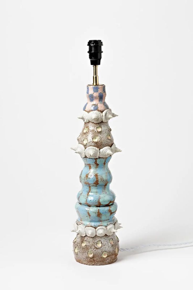 a tall blue and white vase sitting on top of a table