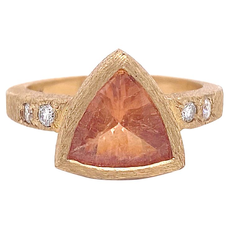 This original orange citrine ring was hand fabricated in our shop and is a one-of-a-kind. This unique gemstone was hand selected by our owner and is a unique light orange color. The bezel was handmade and the band on the ring has a diamond on either side that is set flush with the gorgeous 18 karat yellow gold. The gold has a rich, buttery color and has a fabulous rock finish. The citrine is a nice size with 1.69 carats and is flanked by a gorgeous, bright, white diamond. The details for this be Modern Orange Gemstone Rings, Orange Topaz Ring With Accent Stones For Gift, Orange Topaz Ring With Center Stone For Gift, Orange Topaz Ring With Accent Stones As Gift, Orange Topaz Ring With Accent Stones, Orange Topaz Gemstone Rings, Orange Topaz Ring With Center Stone As Gift, Orange Citrine Jewelry With Center Stone, Gift Orange Topaz Gemstone Ring