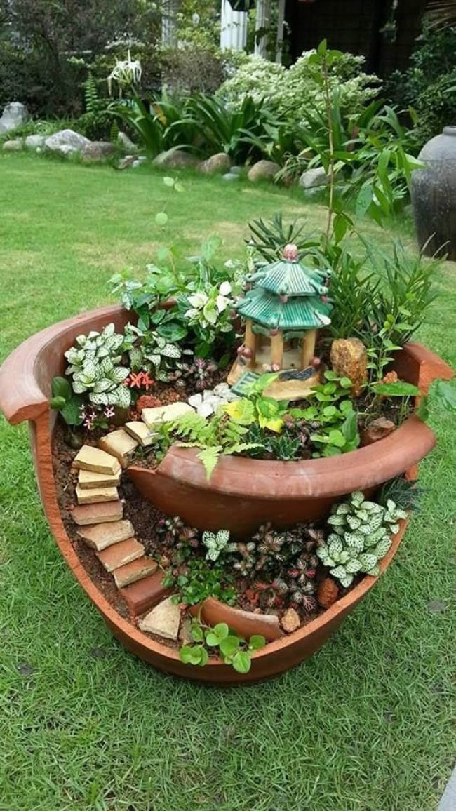 a potted planter filled with lots of plants on top of a grass field