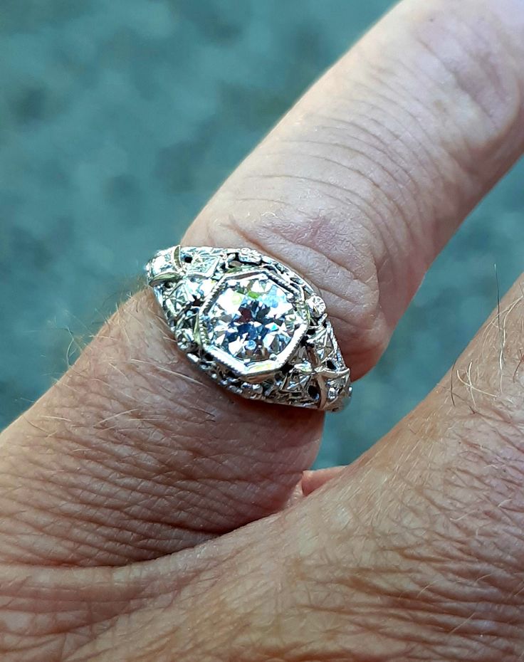 A wonderful Victorian band with great filigree detail. The center stone measures out at .80 ct and has a clarity of SI1 and G color. There is a small natural crystal on the girdle. On either side are 2 @.05ct diamonds set in diamond shape gold. The band weighs 2.5 grams and is is excellent condition. It measures 8.5mm across the top. Antique Brilliant Cut Diamond White Ring, Antique Brilliant Cut Diamond White Diamond Ring, Antique Diamond White Diamond Ring With Brilliant Cut, Antique Diamond Ring With Center Stone, Antique Diamond White Diamond Ring, Antique Diamond Rings With Vvs Clarity, Antique Diamond White Ring With Center Stone, Brilliant Cut Diamond Ring For Marriage, Antique Diamond Ring With Prong Setting